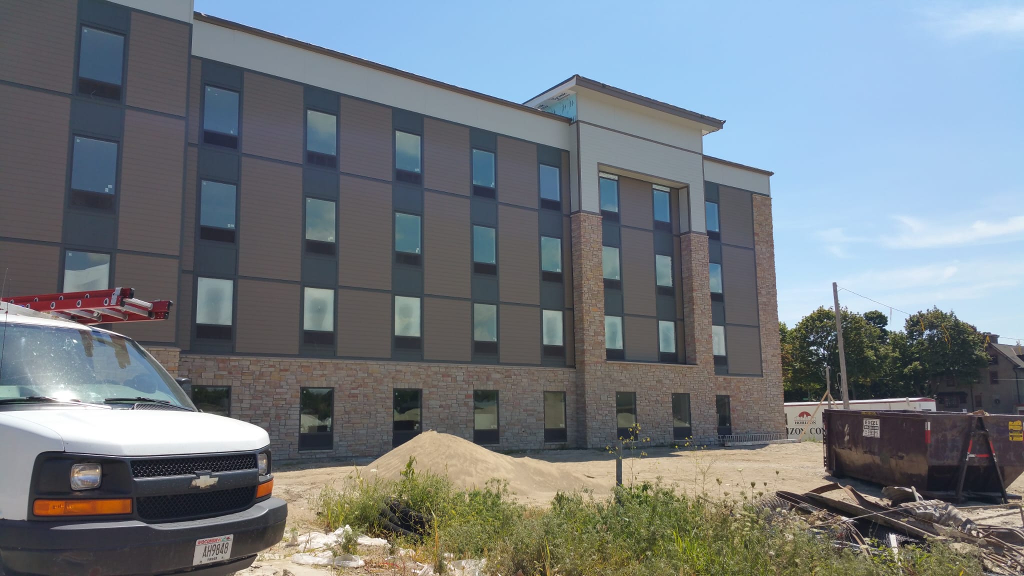 Commercial hotel exterior with stone and panel siding